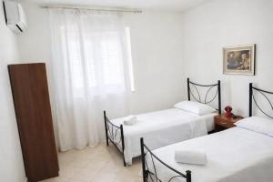 a room with two beds and a window at WHITE COAST APARTMENTS - Family Stays and Free Parking in Realmonte