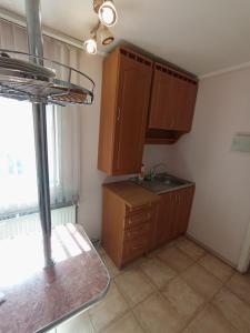 a small kitchen with wooden cabinets and a window at Котедж - Prestige in Vorokhta