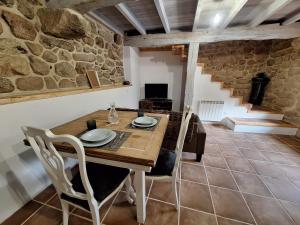 a dining room with a wooden table and chairs at Casa da mestre in Crecíente