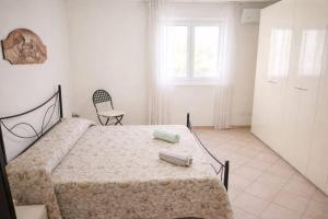 a bedroom with a bed and a chair and a window at WHITE COAST APARTMENTS - Family Stays and Free Parking in Realmonte
