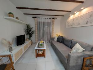 a living room with a couch and a tv at Jardín secreto del Mar Menor, La Manga in San Javier
