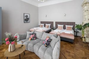 a living room with a couch and two beds at Cracow Main Square Apartments in Krakow