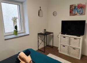 a living room with a flat screen tv on a cabinet at Apartment Mateo 2 mit Meeresblick und Mateo 1 mit Gartenblick in Selce +29 photos