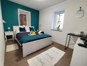 a bedroom with a bed with a green wall at Apartment Mateo 2 mit Meeresblick und Mateo 1 mit Gartenblick in Selce