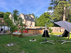 a yard with two chairs and an umbrella at Appartement de luxe "L'Écrin de l'Amour" in Saint-Avertin