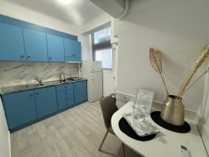 a kitchen with blue cabinets and a table with a vase at Assamaris in Asprovalta