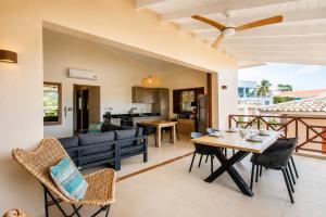 a dining room and living room with a table and chairs at JeVakantie Spanish Water Apartments B7 and C8 with Infinity Pool near Jan Thiel in Willemstad