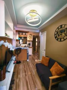 ein Wohnzimmer mit einer Couch und einer Uhr an der Wand in der Unterkunft Marcus Tiny House - Aesthetic in Cabanatuan City in Bangad