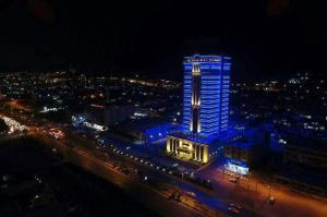 a tall building with lights on it at night at Crixus Hotels Duhok in Duhok