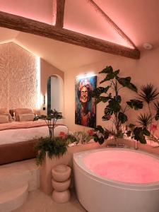 a large bathroom with a tub and a bed at La Casita Rosa in Valras-Plage
