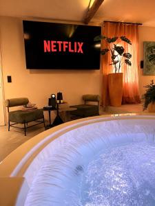 a hot tub in a waiting room with a netflix sign at La Casita Rosa in Valras-Plage