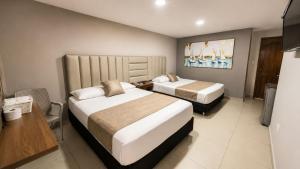 a hotel room with two beds and a desk at Fontamar 43 in Barranquilla +3 photos
