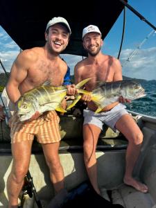 two men on a boat with fish in their hands at La Roca House in El Valle