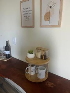 a wooden shelf with mugs and a bottle of wine at Chalé com lareira externa e vista para o Pico do Lopo in Extrema