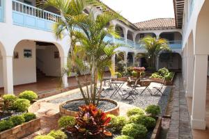 a courtyard with a palm tree in a building at Hotel Aqua Vitae in Villa de Leyva