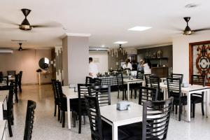 a restaurant with tables and chairs and people in the kitchen at Fontamar 43 in Barranquilla