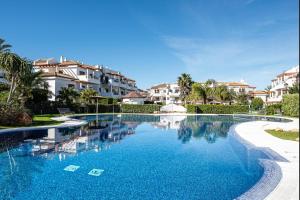 a swimming pool in a resort with houses in the background at coto 4 11 in Novo Sancti Petri