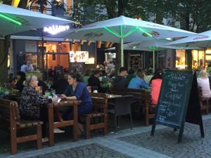 a group of people sitting at tables at a restaurant at Six! Eat Work Sleep in Brühl