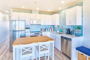 a kitchen with white cabinets and a wooden counter top at Saltwater & Sunsets in Long Beach