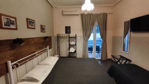 a bedroom with a bed and a large window at Garden House Katerina in Leptokarya