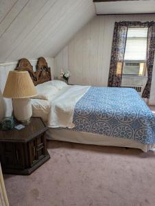 a bedroom with a bed and a table with a lamp at Isa-e Home Stay in Hempstead