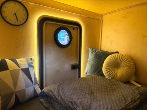 ein Schlafzimmer mit einem Bett und einer Uhr an der Wand in der Unterkunft Tinydorf-Sinsheim in Sinsheim
