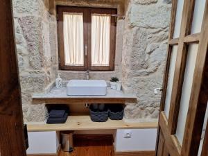 a bathroom with a sink and a stone wall at Casa da mestre in Crecíente +22 photos