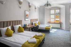 a hotel room with two beds and a chair at Cracow Main Square Apartments in Krakow