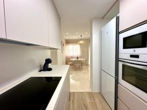 a kitchen with white cabinets and a counter top at Twin Beach in Torrenueva +8 photos
