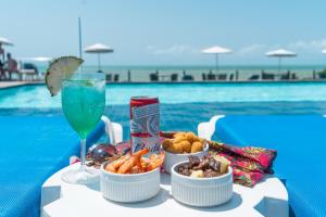 a table with food and a drink next to a pool at El Aram Imirá Beach Resort in Natal