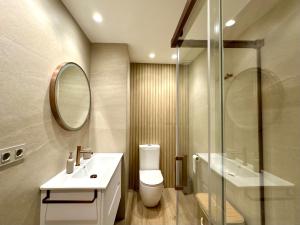 a bathroom with a toilet and a sink and a mirror at Twin Beach in Torrenueva