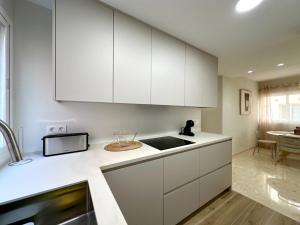 a kitchen with white cabinets and a sink at Twin Beach in Torrenueva
