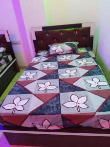 a bed with a quilt with flowers on it at New MORVINAND PALACE in Khātu