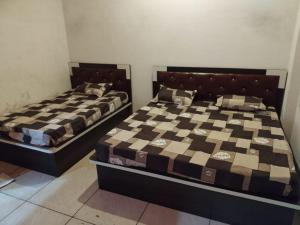 two beds sitting next to each other in a bedroom at New MORVINAND PALACE in Khātu