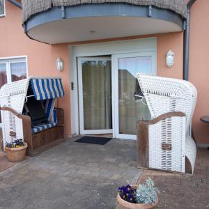 two wicker chairs sitting in front of a door at Dia Mare in Ueckeritz