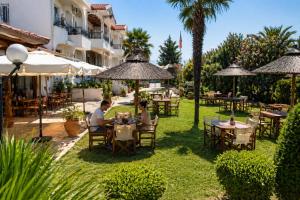 two people sitting at tables under umbrellas at a restaurant at Assamaris in Asprovalta