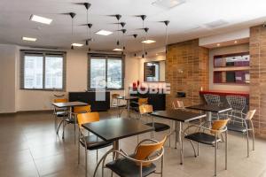 a dining room with tables and chairs and windows at Lobie Queen Ipanema in Rio de Janeiro
