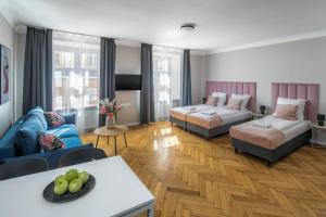 a living room with two beds and a couch at Cracow Main Square Apartments in Krakow