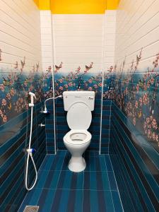 a bathroom with a toilet with blue tiled walls at G3 house Pondicherry in Pondicherry