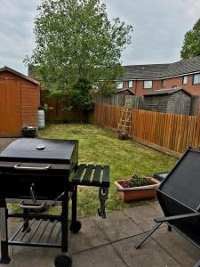 a backyard with a grill and a garden with a fence at Central Hideout in Birmingham