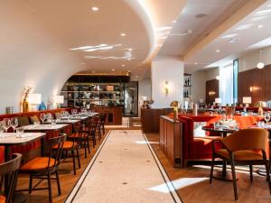 a restaurant with tables and chairs and a bar at Mercure Villefranche-sur-Saône in Villefranche-sur-Saône