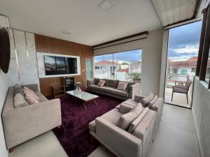 a living room with two couches and a tv at Duplex mansão Manaus in Manaus