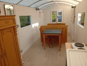 a small kitchen with a table in a tiny house at De smishoeve "Herdershut" in Heers