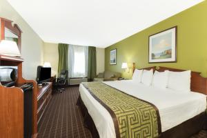a hotel room with a large bed and a television at Baymont by Wyndham Louisville South/Shepherdsville/I 65 in Brooks