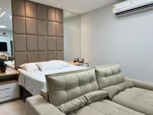 a bedroom with a couch next to a bed at Duplex mansão Manaus in Manaus