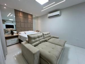 a living room with a couch and a bed at Duplex mansão Manaus in Manaus