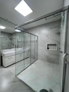a bathroom with a glass shower and a sink at Duplex mansão Manaus in Manaus +67 photos