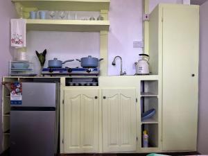 a small kitchen with a stove and a refrigerator at CJ's Creole Hideaway in Castries