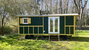 a green and yellow tiny house in a field at The Shepherds Hut in Wallingford +3 photos