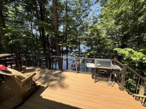 a grill on a wooden deck with a view of the water at HOLIDAY COVE - LIMIT 8 villa in Naples